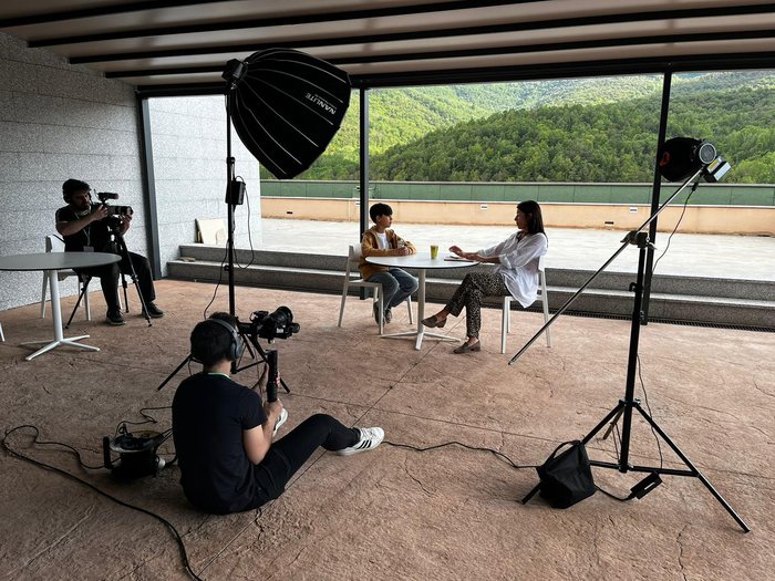 Crew filming an interview on a terrace overlooking the mountains