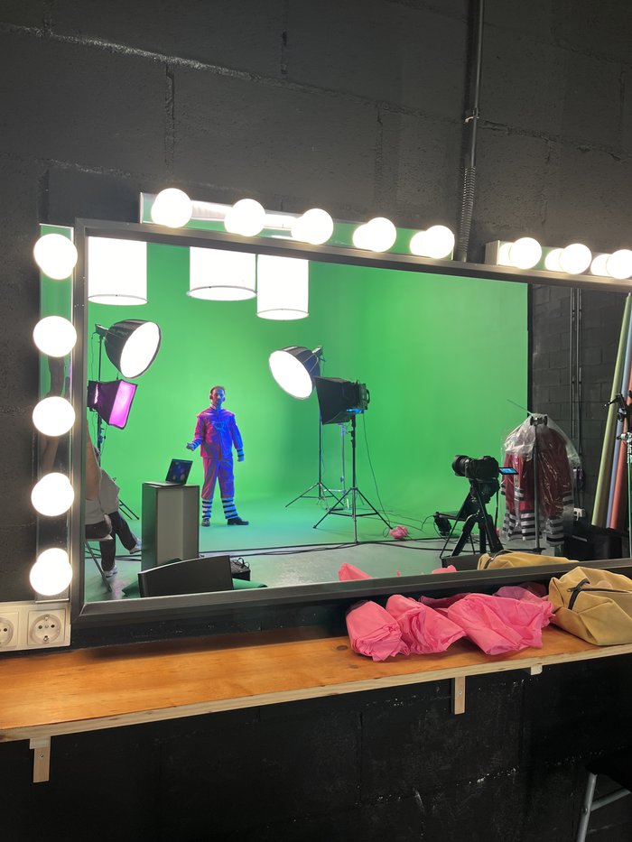 Mirror reflection of a green-screen shoot with colourful wardrobe