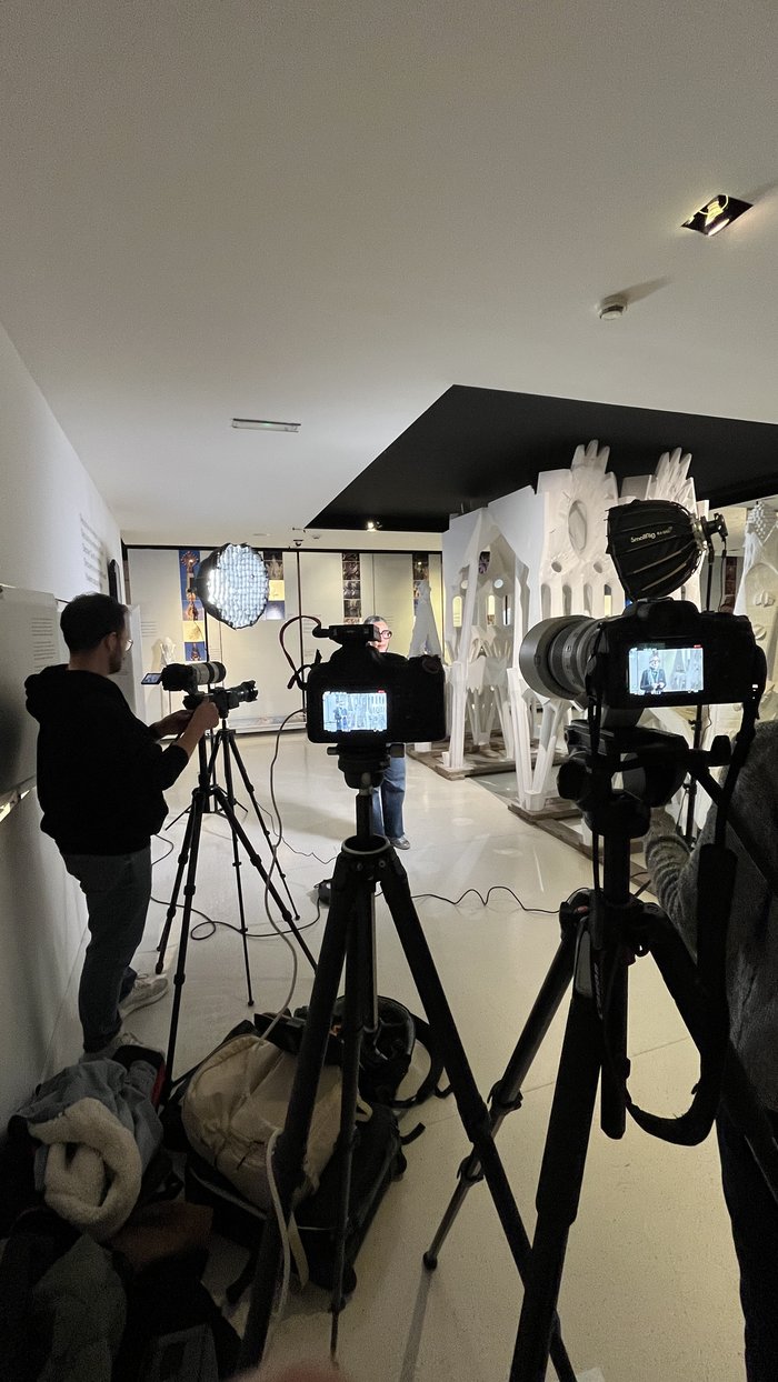 Crew filming inside an exhibition with white sculptures