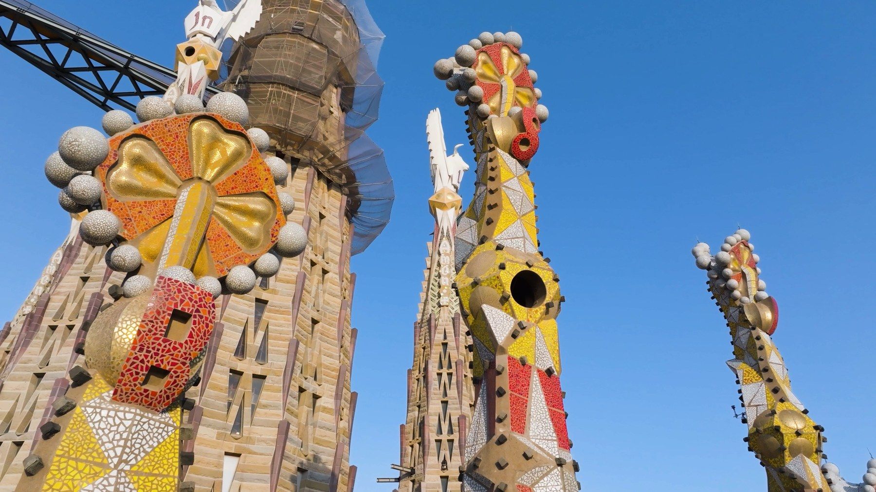 Close-up of the Sagrada Família's spires against a deep blue sky
